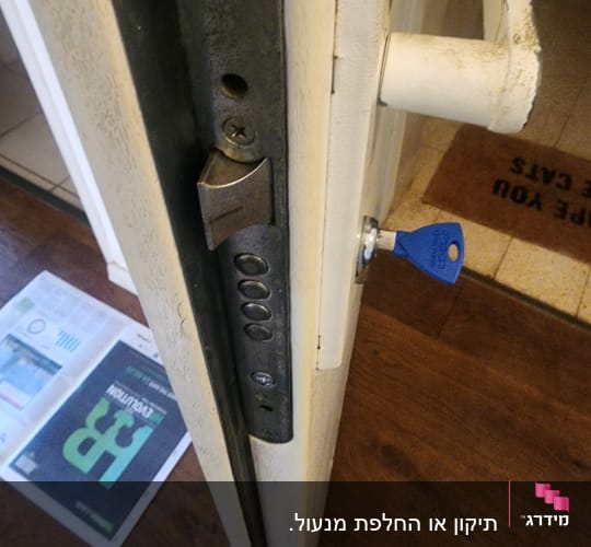 מנעול דלת עם מפתח כחול בדלת עץ